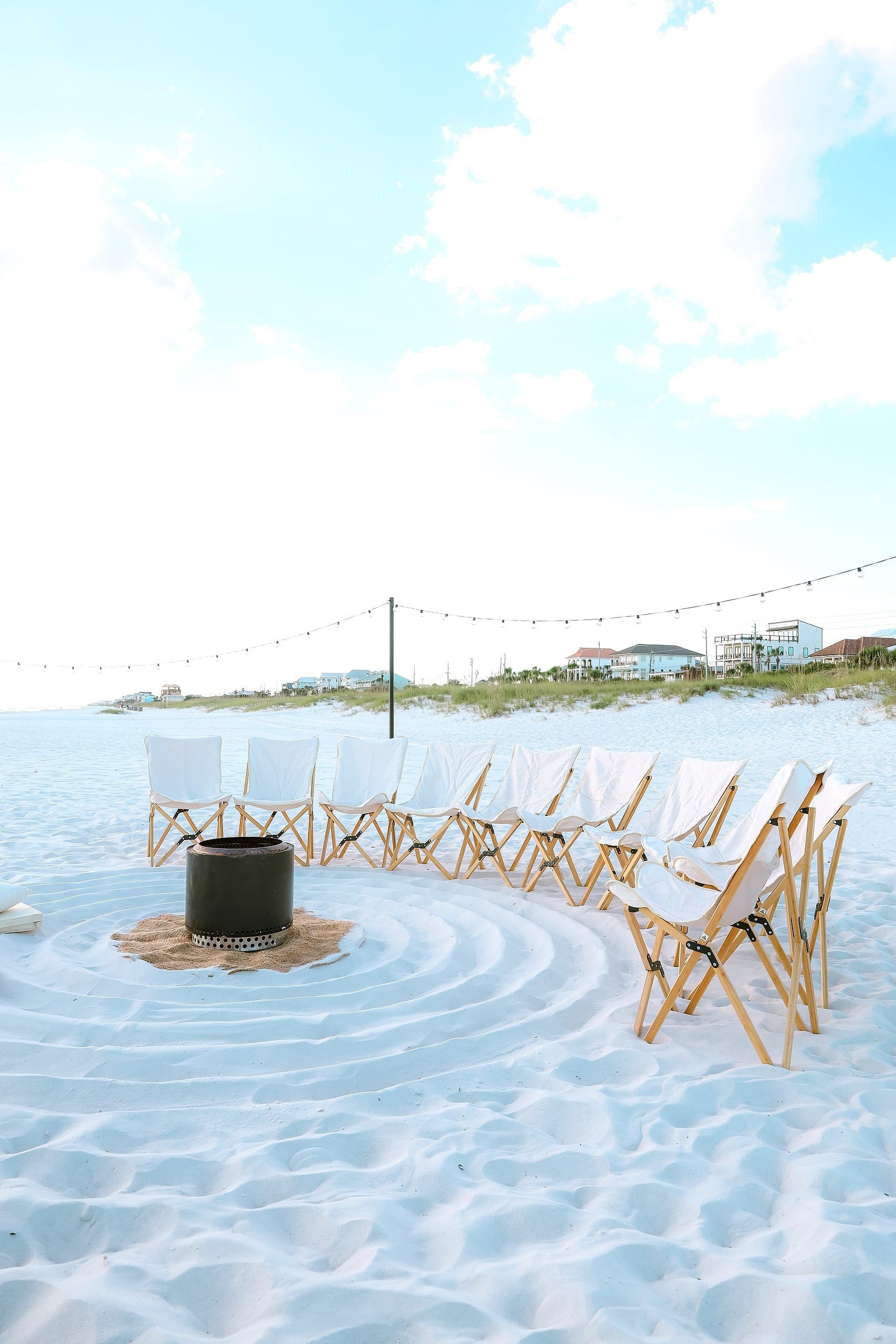 Styled chairs on the sand with the dune homes behind